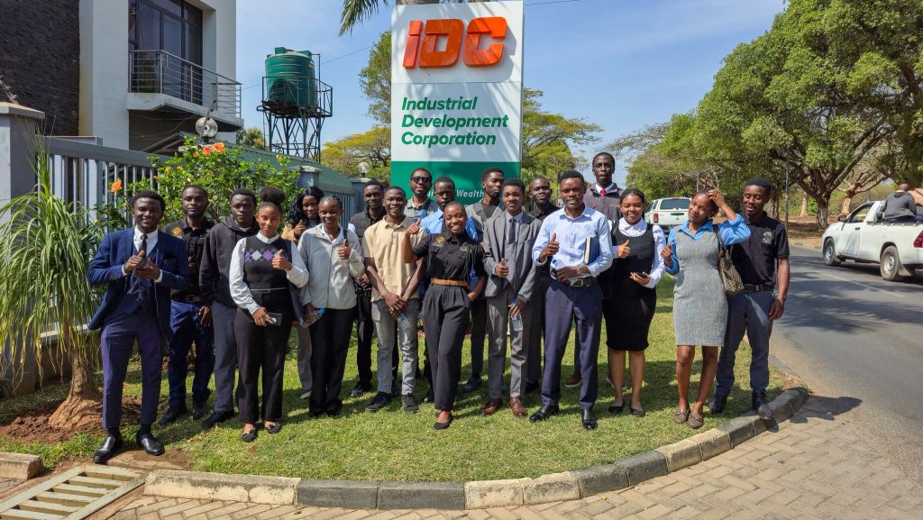 UNZADESA students and IDC representatives gather beside the IDC sign.