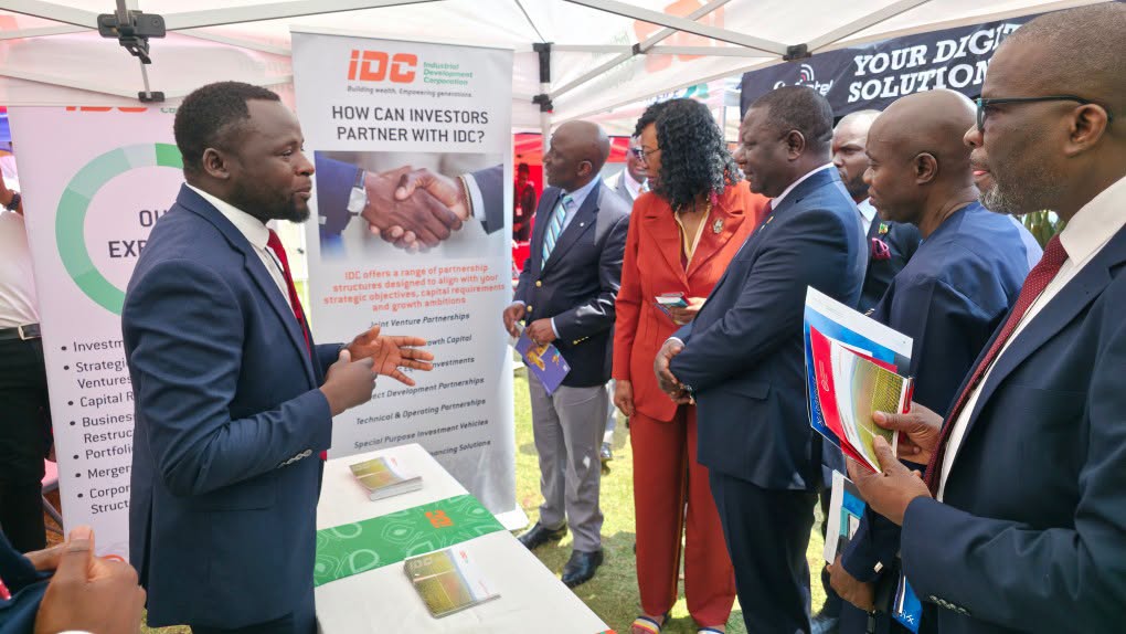 Visitors discussing investor partnership opportunities at the IDC exhibition stand