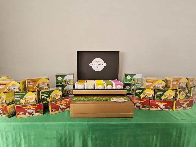 Packaged Kawambwa Tea products on display, including black tea, green tea and instant brew blends