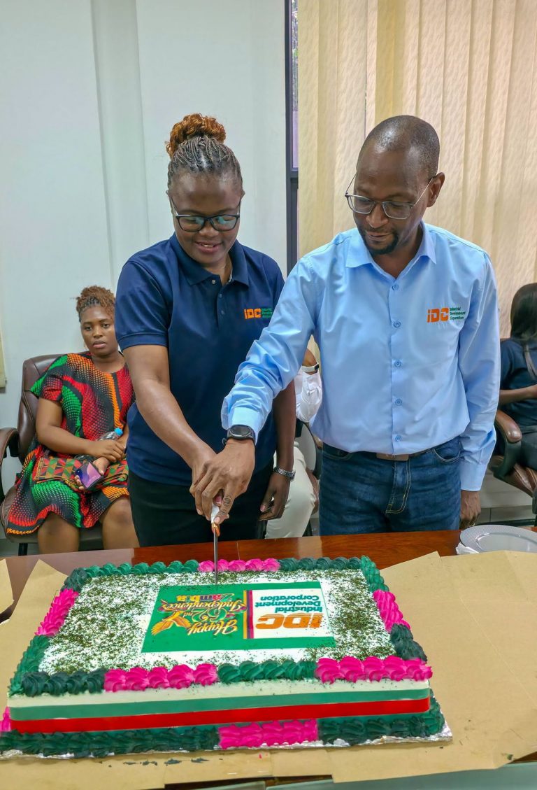 IDC staff cut an Independence Day cake decorated in Zambian national colours and the IDC logo.
