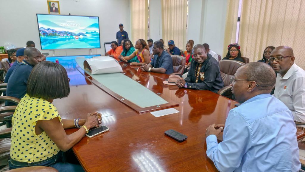 IDC staff gather around the boardroom table for the Independence anniversary celebration.