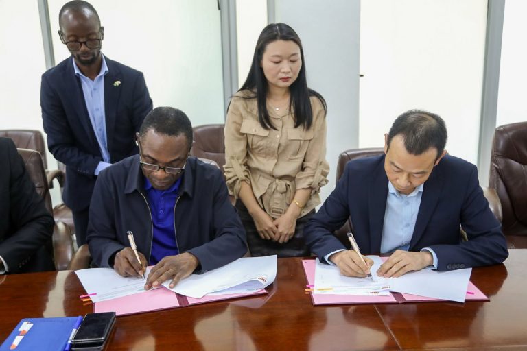 IDC and Rong Xing representatives sign the letter of intent at a conference table.