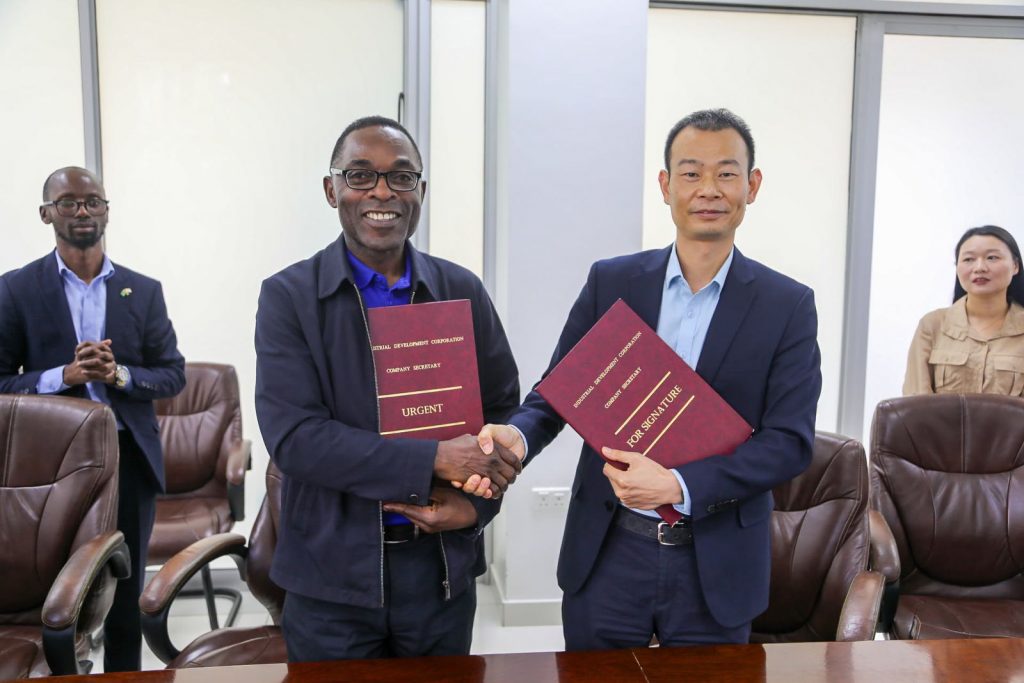IDC and Rong Xing representatives shake hands and display signed documents.