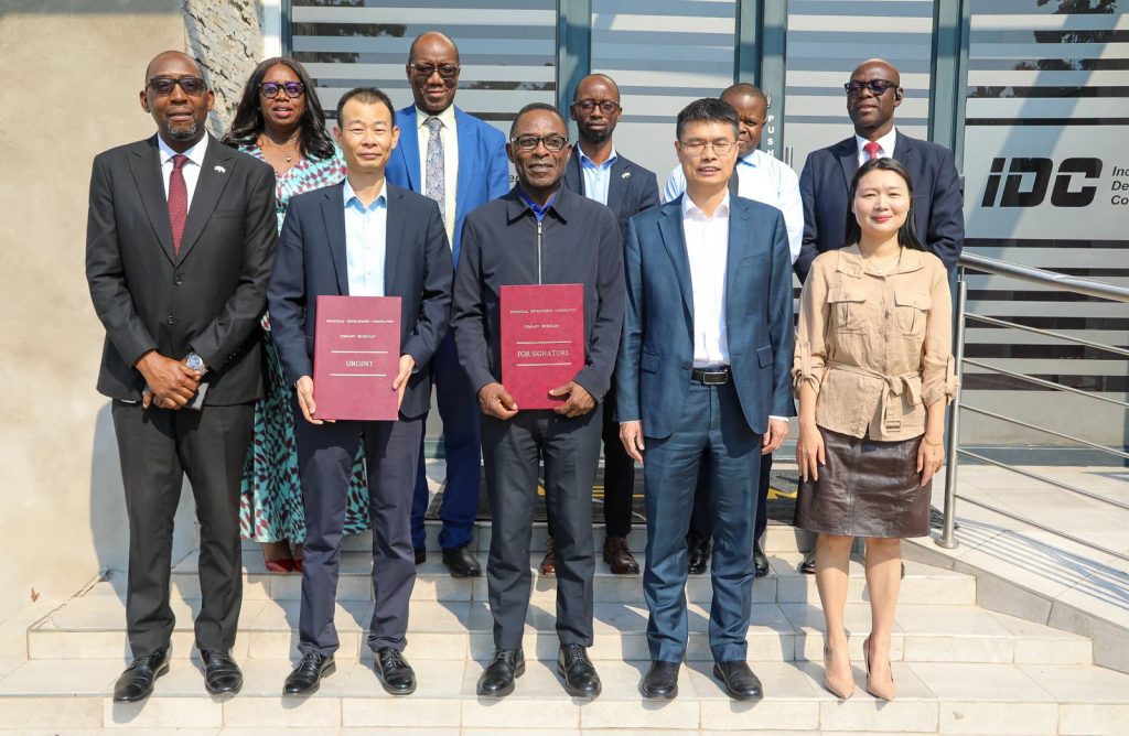 IDC and Rong Xing delegates pose together with signed documents outside IDC offices.