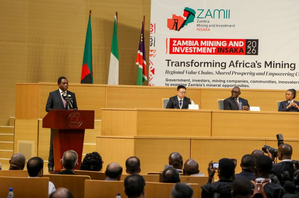 President Hakainde Hichilema addresses the conference while other speakers sit on the stage.