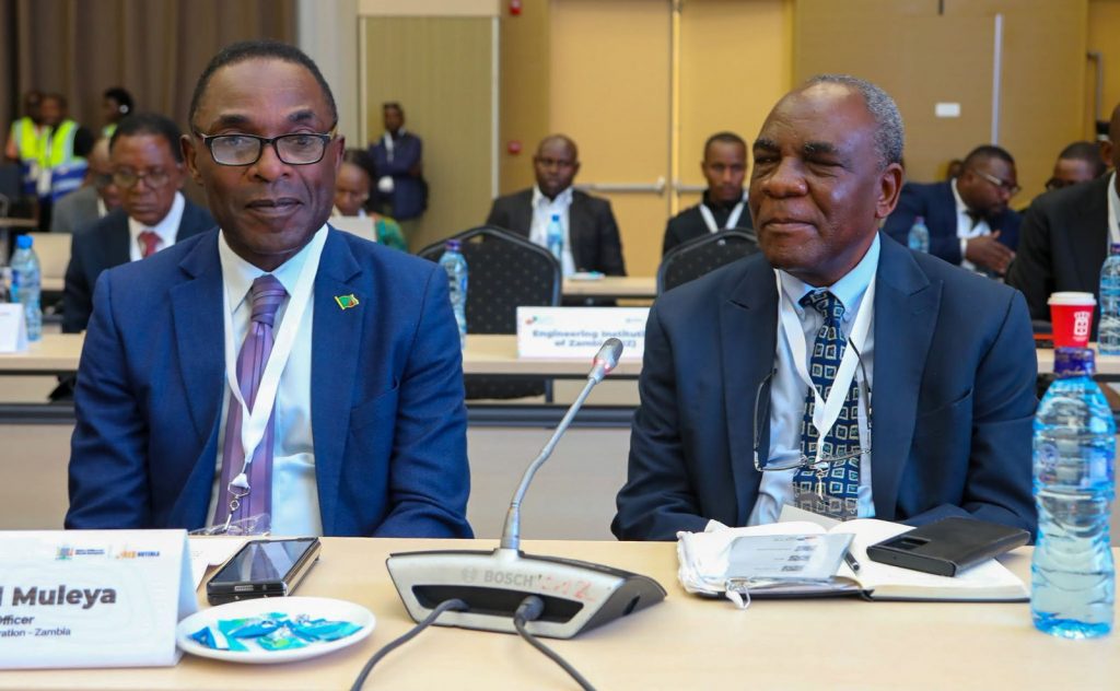 IDC Chief Executive Officer Mr. Cornwell Muleya and a fellow delegate listen during the conference.