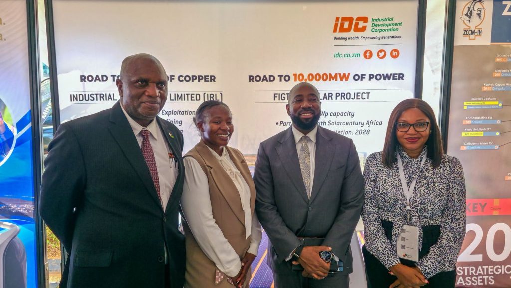 IDC representatives pose at the IDC exhibition stand, with boards showing national power and copper targets.