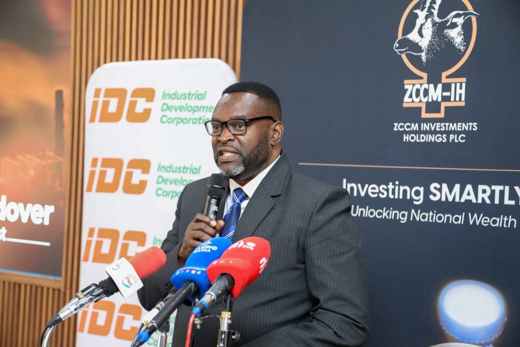 A representative delivers remarks beside IDC and ZCCM-IH banners