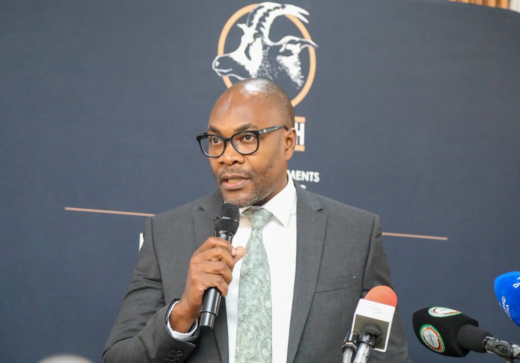 A speaker delivers remarks in front of a ZCCM-IH banner