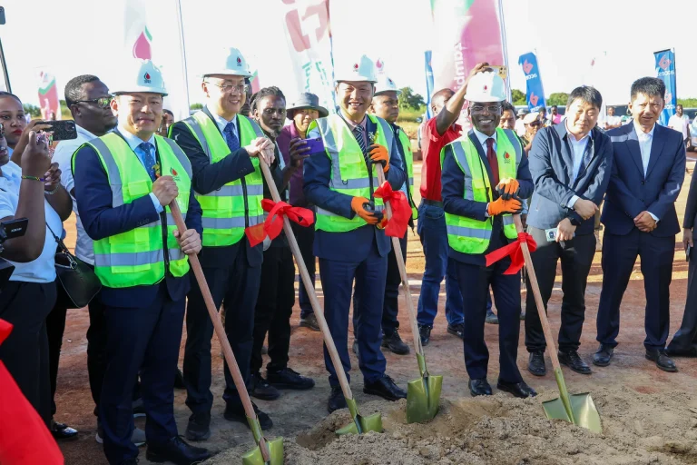 Officials wearing safety vests and hard hats break ground with spades at the ZPEC refinery ceremony.